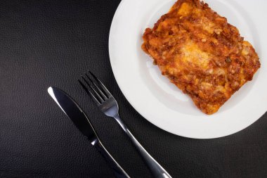 Bolonez soslu lazanya, jambon peyniri, domates sosu ve kıyma. Popüler mutfağın en iyi görünümü.