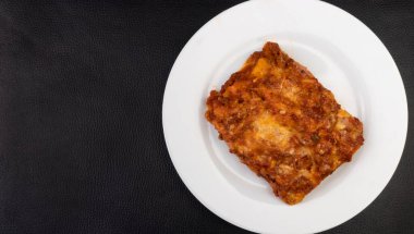 Bolonez soslu leziz lazanya, jambon peyniri, domates sosu ve kıyma. Metinler için boş alanı olan üst görünüm yakın çekim fotoğrafçılığı.