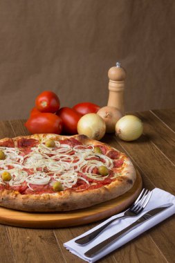 Sucuklu pizza, soğan dilimleri, mozzarella peyniri ve yeşil zeytinli gurme fotoğrafı. Görüntüyü oluşturmak için kırsal formundaki bileşenler.