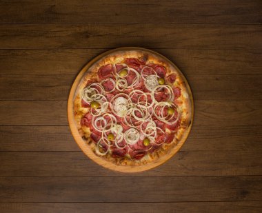 Pepperoni pizza, soğan dilimleri, mozzarella peyniri ve yeşil zeytin. Tahta bir tahtanın üzerinde. Metinler ve grafik sanatları için geniş alanları olan üst düzey gastronomik fotoğrafçılık. Yemekler ortaya..