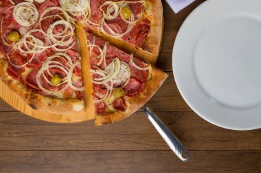 Pepperoni pizza, soğan dilimleri, mozzarella peyniri ve yeşil zeytin. Bir dilim pizza tüketime hazır. En iyi gastronomik fotoğrafçılık.