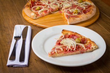 Biberli pizza dilimi soğan dilimleri, mozarella peyniri ve yeşil zeytinle yapılır..