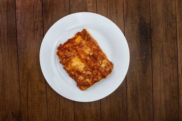 ハムチーズ トマトソース グラウンドビーフで作られたボローニャソースのラザニア ホワイトプレートで提供 トップビュー写真 — ストック写真