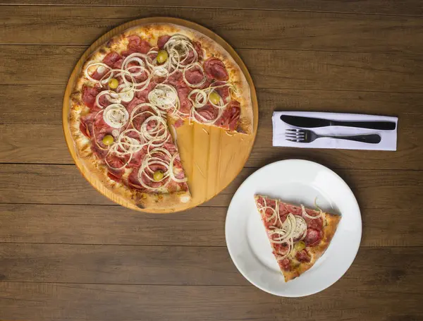 Pepperoni pizza, slices of onions, mozzarella cheese and green olives. Slice of pizza served on the plate. Ample spaces for text.