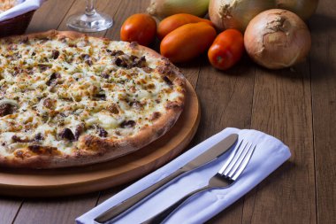 Tahtada etli pizza. Mozzarella, picanha eti, soğan, peynir, domates sosu. Biftek, et, çatal ve bıçak. Ham malzemeli yatay fotoğraf.