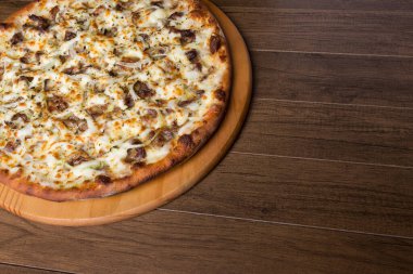 Tahtada etli pizza. Mozzarella, picanha eti, soğan, peynir, domates sosu. Biftek, et. Yazmak için alanı olan fotoğraf.