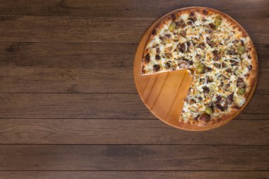 Tahtada etli pizza. Mozzarella, picanha eti, soğan, peynir, domates sosu ve zeytinle yapıldı. Biftek, et. Dilimsiz pizza. Üst resim.