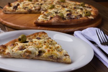 Tabakta servis edilen lezzetli bir dilim. Tahtada etli pizza. Mozzarella, picanha eti, soğan, peynir, sos ve zeytinle yapıldı. Biftek. Çatal ve Bıçak Kafa. Makro fotoğraf.