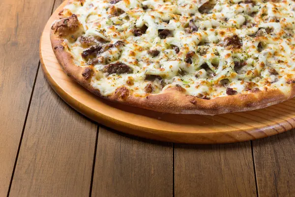 Delicious meat pizza on wooden board. Made with Mozzarella, picanha meat, onion, cheese, tomato sauce. Filet Steak, meat. Horizontal photograph top alignment.