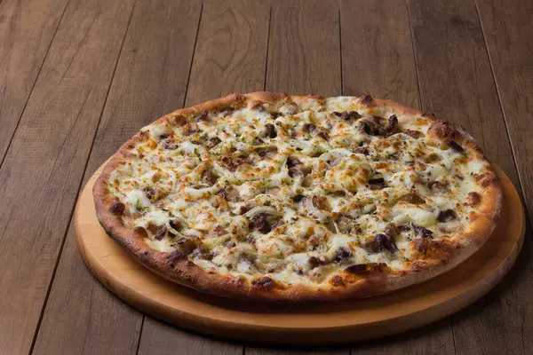 Delicious meat pizza on wooden board. Made with Mozzarella, picanha meat, onion, cheese, tomato sauce. Filet Steak, meat.