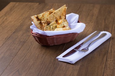 Costini. Baharatlı hamur. Çatal ve bıçak beyaz bir peçetede. Restoranlarda ve pizzacılarda aperatif olarak yiyecek veriliyor. Tipik İtalyan yemekleri. Dikey fotoğrafçılık.