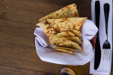 Costini. Baharatlı hamur. Çatal ve bıçak beyaz bir peçetede. Restoranlarda ve pizzacılarda aperatif olarak yiyecek veriliyor. Tipik İtalyan yemekleri. Yatay üst görünüm.