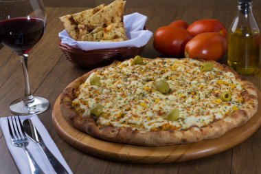 Akılda kalıcı tavuk aromalı pizza. Mozarella, tavuk, krem peynir, yeşil zeytin, mısır ve kırmızı domates sosuyla yapılmış. Kırmızı şarap, porsiyon crostini, zeytinyağı ile servis edilir. peçete..