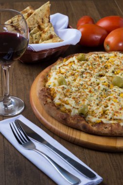 Akılda kalıcı tavuk aromalı pizza. Mozarella, tavuk, krem peynir, yeşil zeytin, mısır ve kırmızı domates sosuyla yapılmış. Kırmızı şarap, porsiyon crostini ve zeytinyağı ile servis edilir..