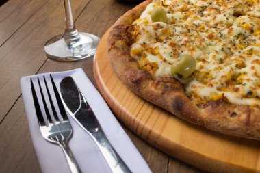 Tahta tahtada servis edilen lezzetli Catupiry Chicken aromalı pizza. Mozarella, tavuk, krem peynir, yeşil zeytin, mısır ve kırmızı domates sosuyla yapılır..