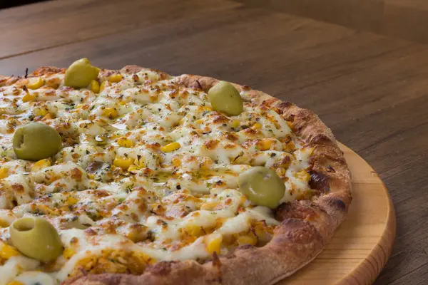 Tahta tahtada servis edilen lezzetli Catupiry Chicken aromalı pizza. Mozarella, tavuk, krem peynir, yeşil zeytin, mısır ve kırmızı domates sosuyla yapılmış. Tipik İtalyan yemekleri..