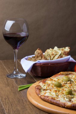 Gratin Loin Pizza. Mozzarella, Kanada usulü sığır filetosu, kremalı süt ve yeşil zeytin. Yanında da biraz crostini, bir kadeh kırmızı şarap, zeytinyağı ve maydanoz var..