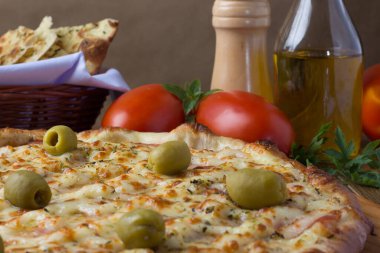 Gratin Loin Pizza. Mozzarella, Kanada usulü sığır filetosu, kremalı süt ve yeşil zeytin. Yanında crostini, kırmızı domates, zeytinyağı, karabiber öğütücü, beyaz peçete ve maydanozda çatal bıçak takımı var. Kapat 1.