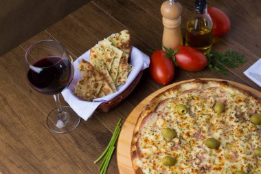 Gratin Loin Pizza. Mozzarella, Kanada usulü sığır filetosu, kremalı süt ve yeşil zeytin. Yanında crostini, bir bardak kırmızı şarap, kırmızı domates, zeytinyağı, karabiber öğütücü