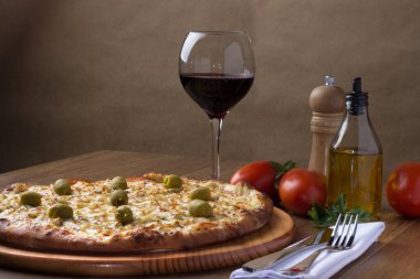 Gratin Loin Pizza. Mozzarella, Kanada usulü sığır filetosu, kremalı süt ve yeşil zeytin. Yanında crostini, bir bardak kırmızı şarap, kırmızı domates, zeytinyağı, karabiber öğütücü