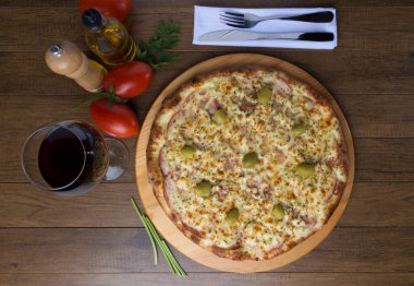 Gratin Loin Pizza. Mozzarella, Kanada usulü sığır filetosu, kremalı süt ve yeşil zeytin. Yanında bir bardak kırmızı şarap, kırmızı domates, zeytinyağı, karabiber öğütücü..
