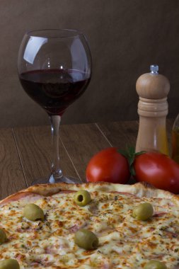 Gratin Loin Pizza. Mozzarella, Kanada usulü sığır filetosu, kremalı süt ve yeşil zeytin. Onlara bir kadeh kırmızı şarap eşlik eder.