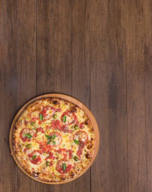 Lezzetli pizza hamuru, Mozzarella, domates, marjoram ve yeşil zeytinle yapılmış pizza. Tahta bir tahtanın üzerinde servis edilmiş. Napoli Pizzası. Yenilenmiş gastronomi. Gurme fotoğraf dikey üstte.