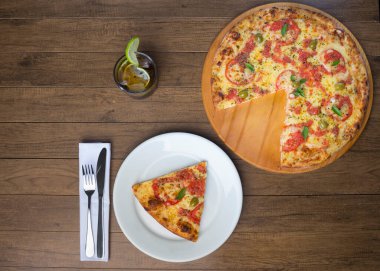 Mozzarella peynirli, domatesli, fesleğenli ve yeşil zeytinli Lezzetli Pizza Marguerita. Süslemek için yanında kola aromalı içecek ve limon dilimi de olacak. Üst Fotoğraf.