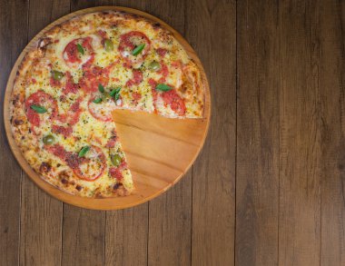 Mozzarella peyniri, domates, fesleğen yaprağı ve ahşap bir tahtanın üzerinde servis edilen yeşil zeytinlerden yapılmış lezzetli pizza Marguerita. Topo 'nun gastronomik fotoğrafı.