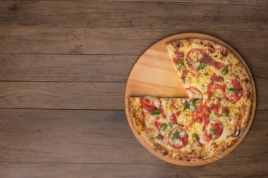 Mozzarella peyniri, domates, fesleğen yaprağı ve yeşil zeytinlerle yapılmış pizza Marguerita 'nın fotoğrafı ahşap bir tahtada servis ediliyor. Yazmak için doğru yere ve doğru elementlere sahip en üstteki fotoğraf