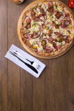 Jambon, bezelye yumurtası, palmiye, pepperoni, soğan, mozzarella ve pastırmadan yapılmış Portekiz pizzası. Tahta tahtada servis edilmiş. Altında metin için boşluk olan en üstteki fotoğraf.