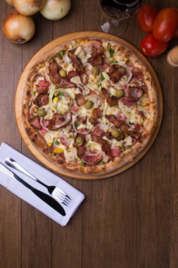 Jambon, bezelye yumurtası, palmiye, pepperoni, soğan, mozzarella ve pastırmadan yapılmış Portekiz pizzası. Tahta tahtada servis edilmiş. Metinler için alt boşluğu olan üstte yakın plan fotoğraf. Popüler Pizza Brezilya.