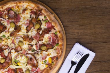Jambon, bezelye yumurtası, palmiye, pepperoni, soğan, mozzarella ve pastırmadan yapılmış Portekiz pizzası. Tahta tahtada servis edilmiş. Üst yakın plan fotoğraf. Restoranlar ve Pizzerialar. Metinler için boşluk .