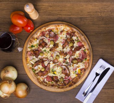 Jambon, bezelye yumurtası, palmiye, pepperoni, soğan, mozzarella ve pastırmadan yapılmış Portekiz pizzası. Tahta tahtada servis edilmiş. Üst yakın plan fotoğraf. Merkezi elementler. Mesaj için yer var. Pizzacı..