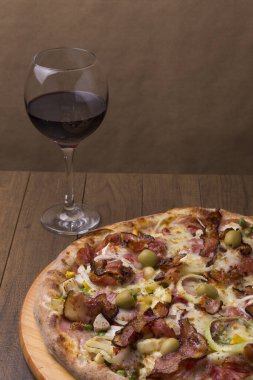 Yanında bir bardak kırmızı şarap eşliğinde Portekiz pizzası. Yakın çekim fotoğrafçılık.