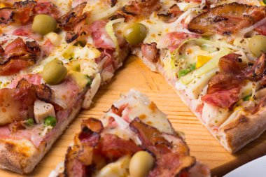 Jambon, bezelye yumurtası, palmiye, pepperoni, soğan, mozzarella ve pastırmadan yapılmış Portekiz pizzası. Bir dilim pizzanın yakın çekim fotoğrafı..