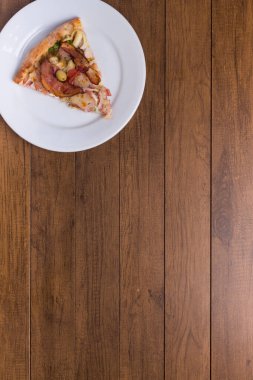 Tabakta servis edilen pizza dilimi. Jambon, bezelye yumurtası, palmiye, pepperoni, soğan, mozzarella ve pastırmadan yapılmış Portekiz pizzası. Metinler ve illüstrasyonlar için geniş boşluklu en üstte.