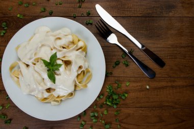 Beşamel soslu ve fesleğen yapraklı Tagliatelle makarnası. Beyaz soslu makarna. Metin için alanı olan en üstteki görüntü fotoğrafı.