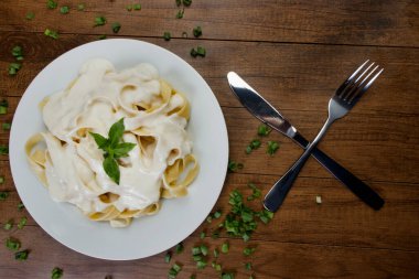 Bechamel Sauce ve Basil Leaves ile servis edilen Lezzetli Tagliatelle Pasta. Beyaz soslu makarna. 