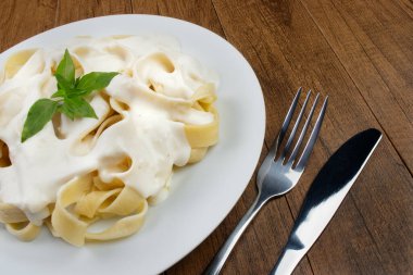 Beşamel soslu ve fesleğen yapraklı Tagliatelle makarnası. Beyaz soslu makarna..