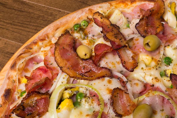 Jambon, bezelye yumurtası, palmiye, pepperoni, soğan, mozzarella ve pastırmadan yapılmış Portekiz pizzası. Sağ alt köşede yemek sıralı yakın plan fotoğraf..