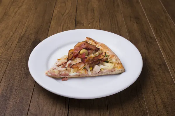 Pizza slice served on the plate. Portuguese pizza made with ham, pea egg, heart of palm, pepperoni, onion and mozzarella and bacon. close-up photo. Gastronomy. Restaurants, Pizzerias and Bars.