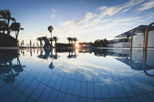 stock image Scenic view of a swimming pool at sunset. Reflection of blue sky and clouds in the water surface