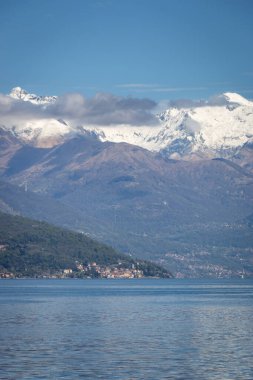 İtalya 'nın Como Gölü' nün manzarası ve kuzey kolu Santa Maria Rezzonico ile kuzeye bakıyor ve arka planda mavi gökyüzüne bakan karlı dağlar var.
