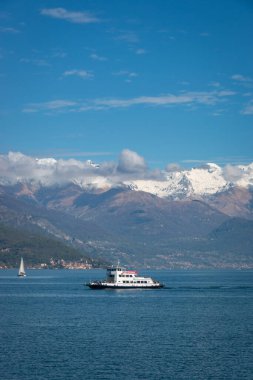 Como Gölü 'nün manzarası ve kuzey kolu mavi gökyüzüne karşı bir yelkenli teknesi ve Stelvio feribotuyla kuzeye bakıyor.