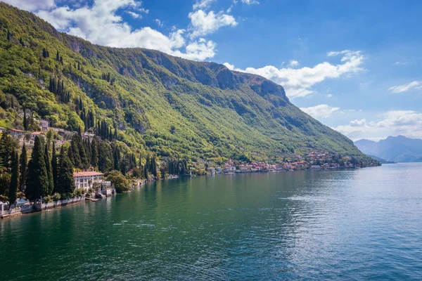 stock image Scenic view of Lake Como eastern shore with Villa Monastero and town of Fiumelatte against blue sky with clouds