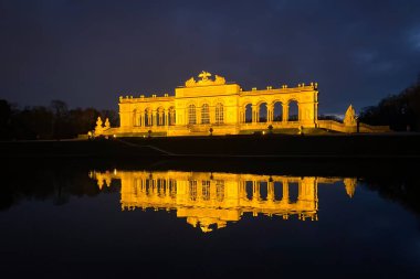 Viyana, Avusturya - 20 Ocak 2020: Schnbrunn Sarayı Parkı 'nda aydınlanan Glorietta bulutlu gökyüzüne karşı kış günü.