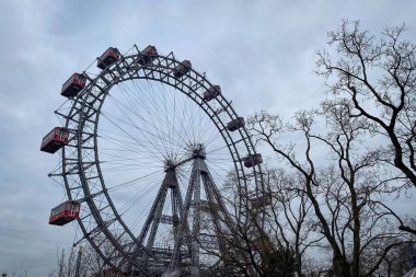 Viyana, Avusturya 'daki Prater lunaparkında kışın bulutlu gökyüzüne karşı dev bir dönme dolap olan Wiener Riesenrad.