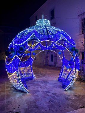 Polonya 'nın Krakow şehrinde gece vakti St. Maria Magdalena Meydanı' nda sokak süsü olarak kullanılan mavi ışıklı dev noel mücevherleri.