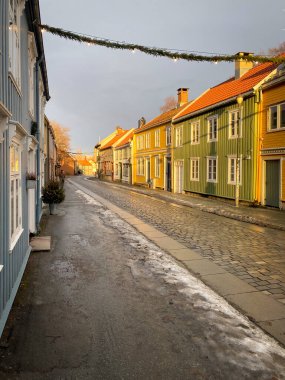 Norveç 'in Trondheim kentindeki Ovre Bakklandet sokağındaki renkli evler bulutlu gökyüzüne karşı